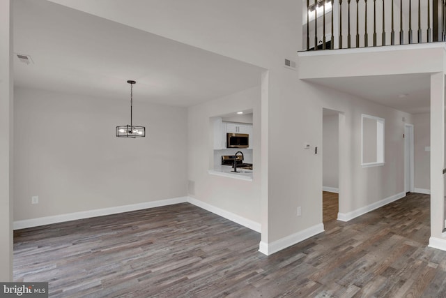 66 Cypress Pl, Newtown, PA 18940 - unfurnished dining area with wood finished floors, a chandelier, baseboards, and a sink