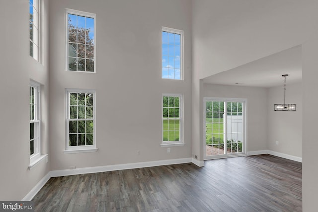 66 Cypress Pl, Newtown, PA 18940 - unfurnished living room with a high ceiling, dark wood-type flooring, a chandelier, baseboards, and plenty of natural light