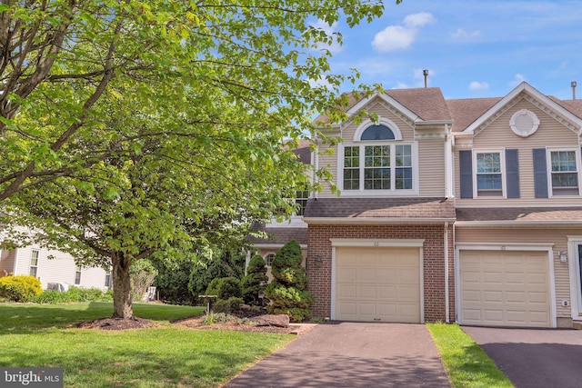 66 Cypress Pl, Newtown, PA 18940 - view of front facade featuring a front yard, asphalt driveway, brick siding, and a shingled roof