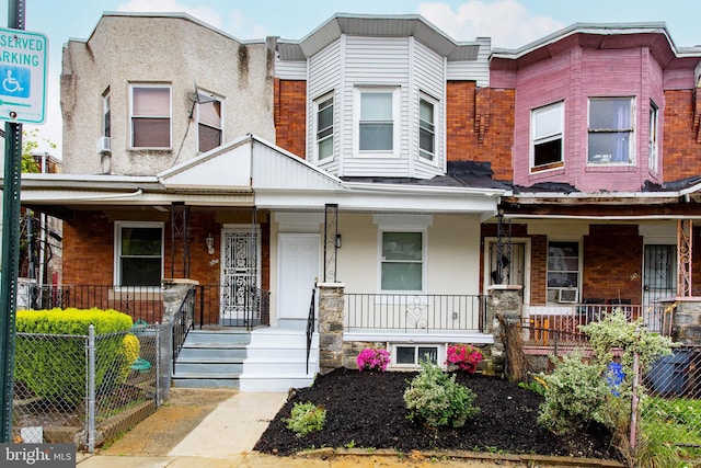multi unit property with a porch, brick siding, and cooling unit