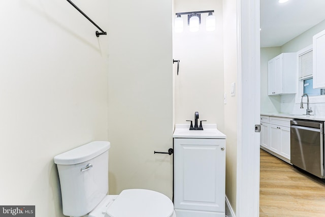 bathroom with vanity, toilet, and wood finished floors