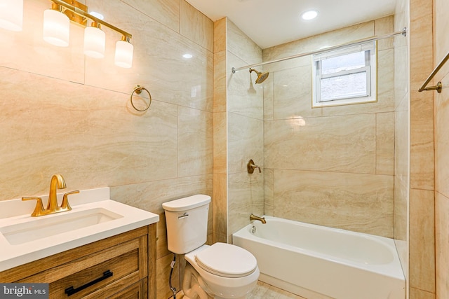 bathroom featuring toilet, tub / shower combination, vanity, and tile walls