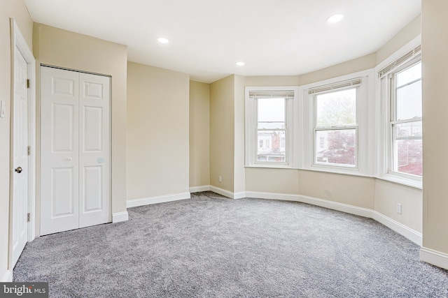unfurnished bedroom with carpet, recessed lighting, baseboards, and a closet