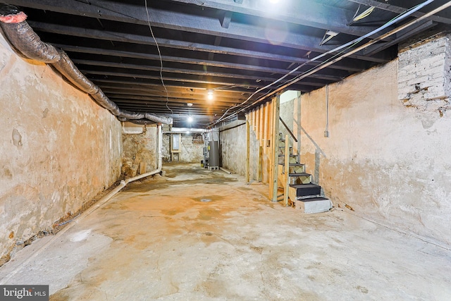 unfinished basement with gas water heater and stairs