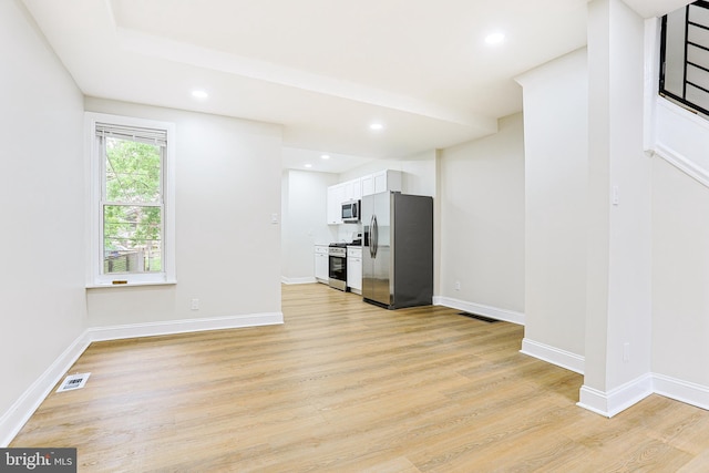 unfurnished living room with light wood-style flooring, recessed lighting, and baseboards