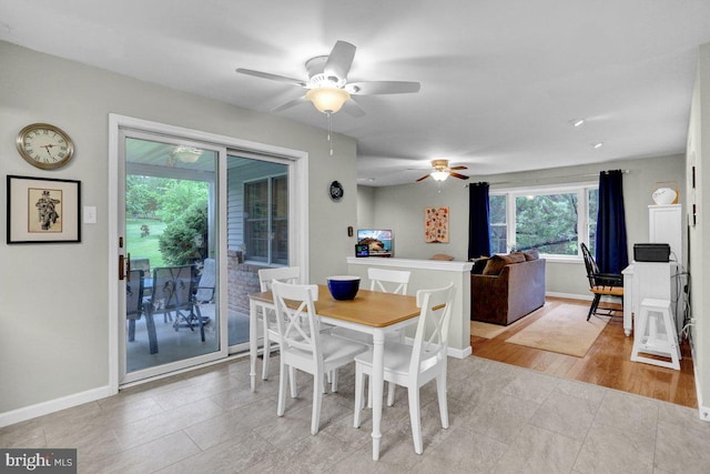 dining room featuring ceiling fan, baseboards, and light tile patterned flooring