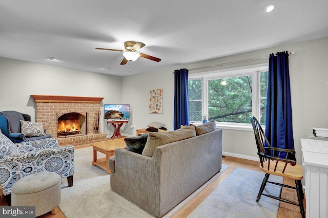 living area with a ceiling fan, a fireplace, baseboards, light wood-type flooring, and recessed lighting