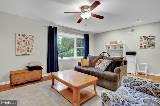living room featuring a ceiling fan, wood finished floors, and baseboards