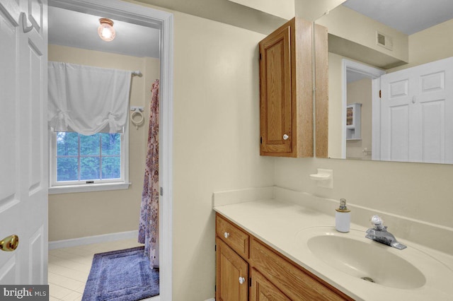 full bath featuring vanity and baseboards