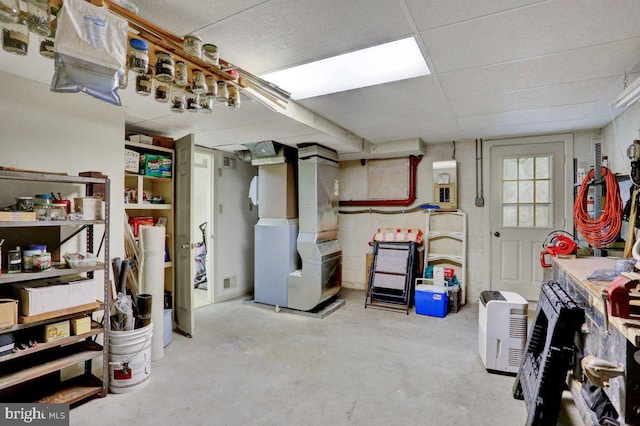below grade area with heating unit and a drop ceiling