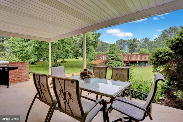 view of patio featuring outdoor dining area and view of scattered trees