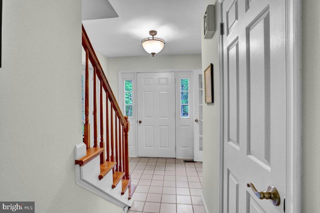 foyer entrance featuring light tile patterned flooring and stairway