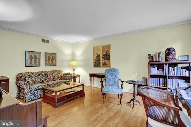 living room featuring ornamental molding, wood finished floors, and baseboards
