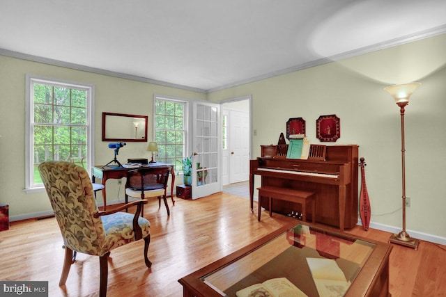 living area featuring wood finished floors, crown molding, baseboards, and an office area