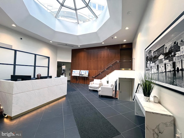 welcome area with a high ceiling, recessed lighting, stairs, and a skylight