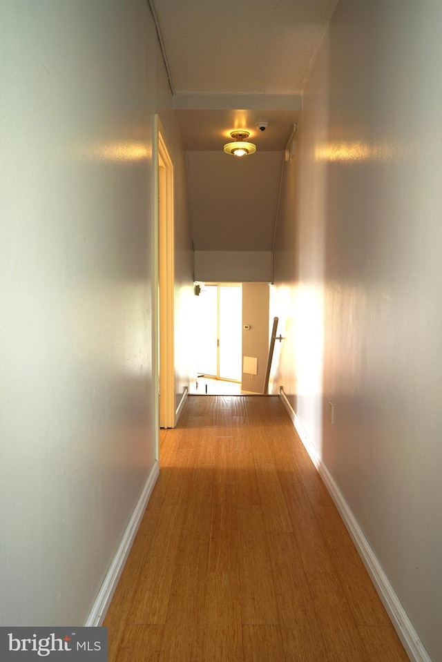 hall featuring baseboards and wood finished floors