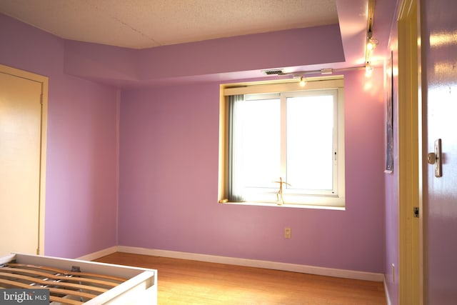 unfurnished room with plenty of natural light, light wood-style flooring, and baseboards
