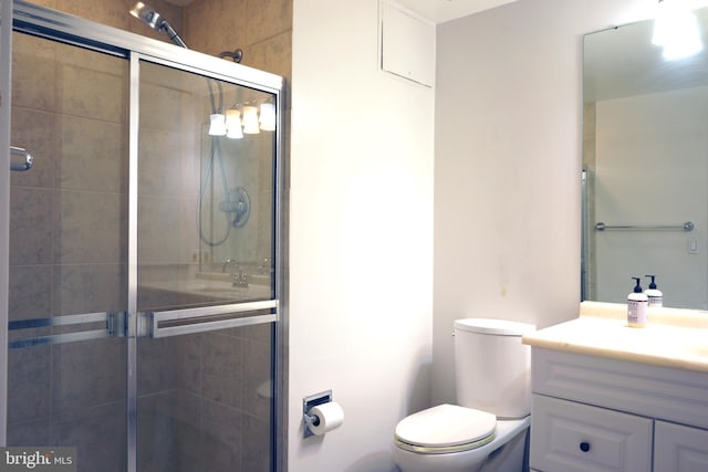 full bathroom with a stall shower, vanity, and toilet