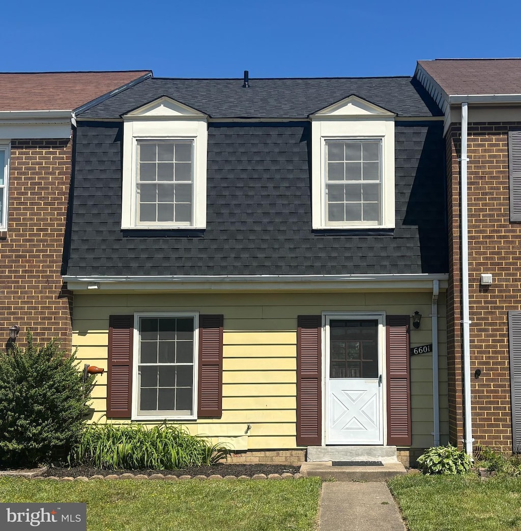 view of front of home with roof with shingles and mansard roof