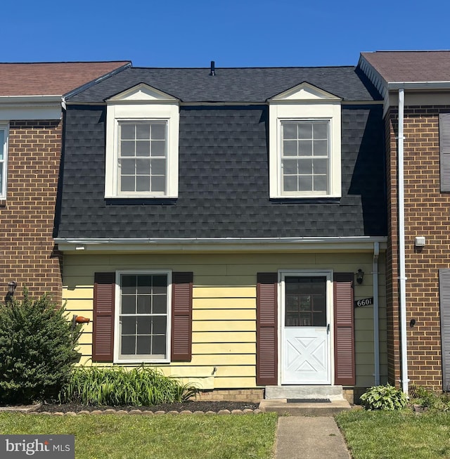 view of front of home with roof with shingles and mansard roof