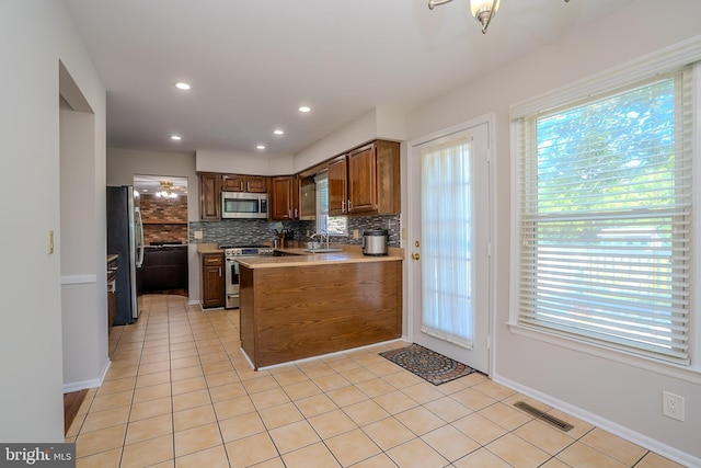 55 Cambridge Way, Princeton Junction, NJ 08550 - kitchen featuring appliances with stainless steel finishes, backsplash, a sink, a peninsula, and light tile patterned floors