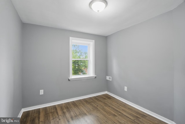 unfurnished room with dark wood finished floors and baseboards