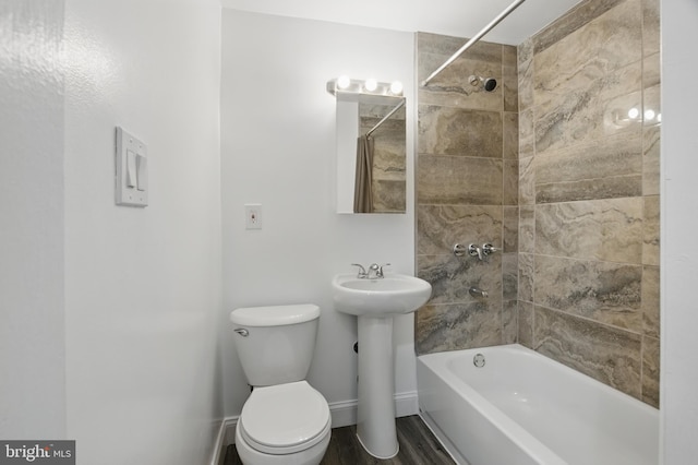 full bathroom featuring  shower combination, toilet, wood finished floors, a sink, and baseboards