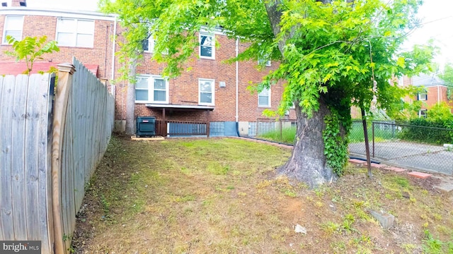 view of yard featuring central AC unit and fence