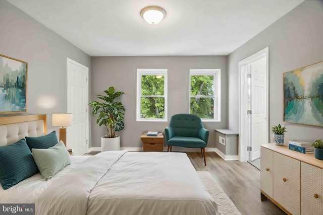 bedroom featuring light wood-style floors and baseboards