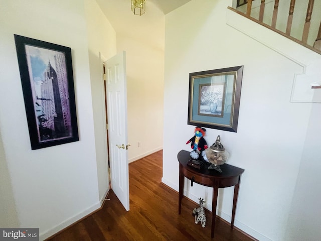 corridor with dark wood-style floors and baseboards