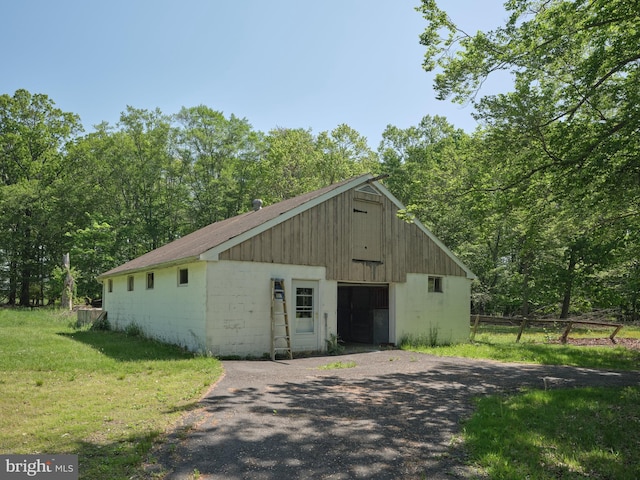 view of outbuilding featuring driveway and an outbuilding
