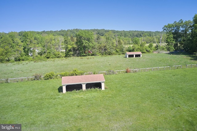 view of yard with a forest view, fence, and a view of countryside