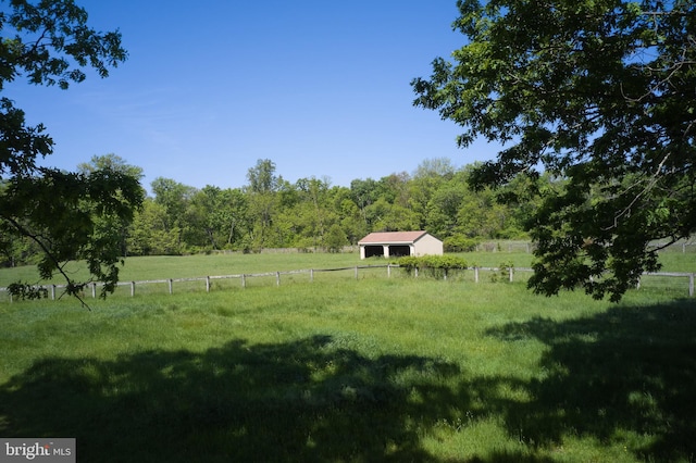view of yard featuring a view of countryside, fence, and a forest view
