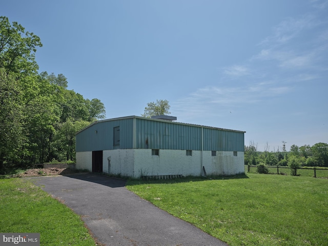 view of outdoor structure featuring asphalt driveway