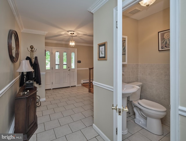 entrance foyer featuring a baseboard radiator, light tile patterned floors, ornamental molding, wainscoting, and tile walls