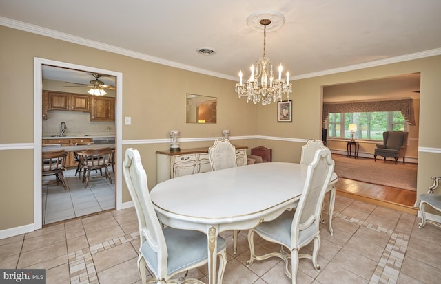 dining space with light tile patterned floors, ornamental molding, a chandelier, ceiling fan, and baseboards