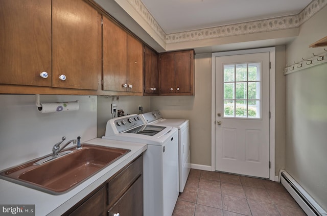 washroom with a baseboard heating unit, cabinet space, washing machine and clothes dryer, baseboards, and light tile patterned floors