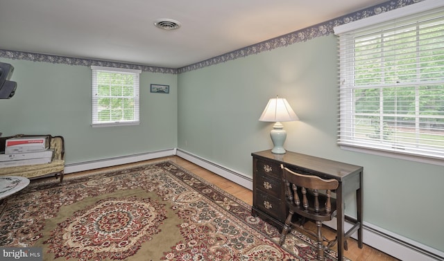 home office featuring a baseboard radiator and wood finished floors