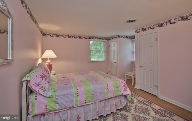 bedroom with wood finished floors and baseboards