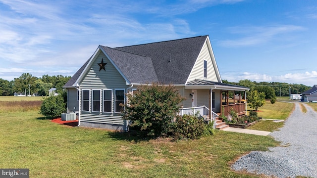 20852 Country Rd, Georgetown, DE 19947 - view of property exterior featuring a porch, a lawn, cooling unit, and a shingled roof