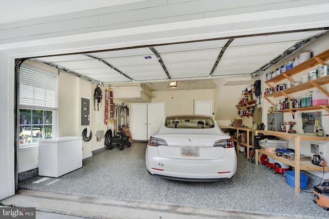 garage featuring electric panel, refrigerator, and a garage door opener