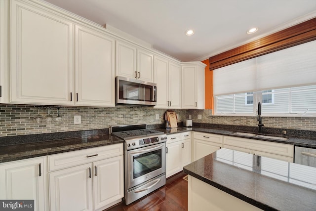 kitchen with stainless steel appliances, a sink, dark wood finished floors, white cabinetry, and tasteful backsplash