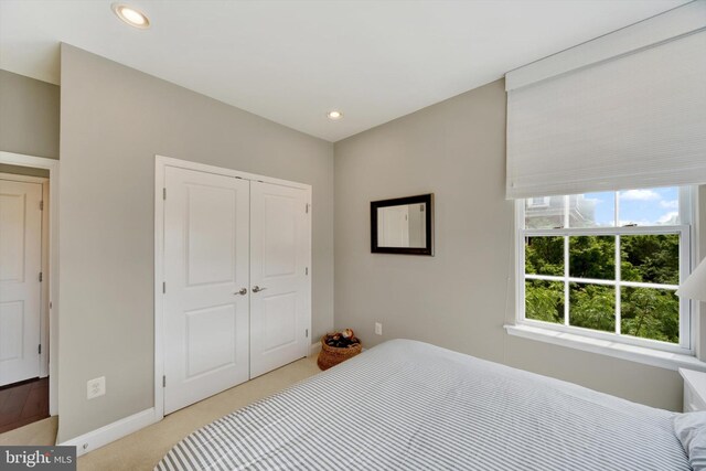 bedroom with light carpet, a closet, baseboards, and recessed lighting
