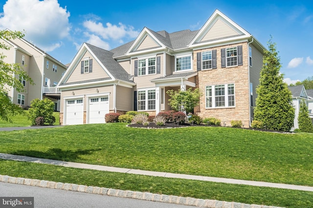 view of front of property featuring a front yard, stone siding, driveway, and an attached garage