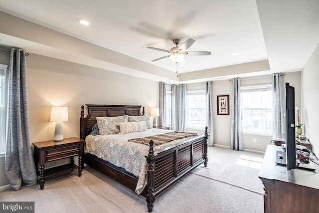bedroom with light colored carpet, baseboards, ceiling fan, a raised ceiling, and recessed lighting