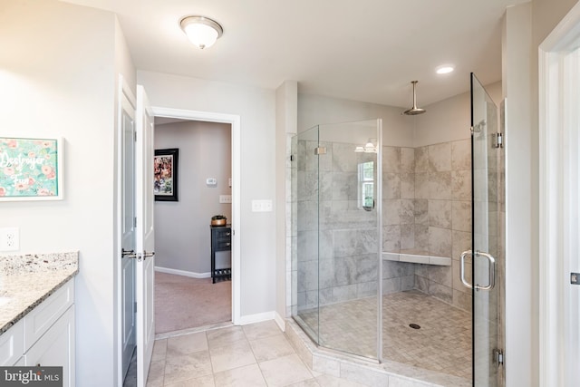 bathroom featuring a shower stall, baseboards, vanity, and tile patterned flooring