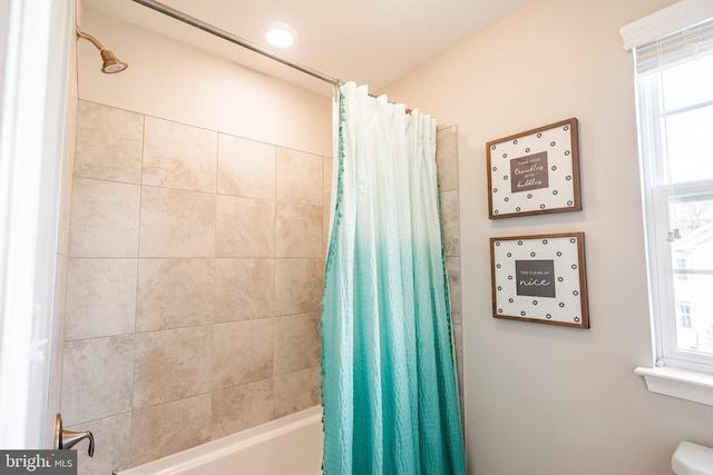 bathroom with shower / tub combo and toilet