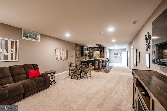 carpeted living area with baseboards, bar, and recessed lighting