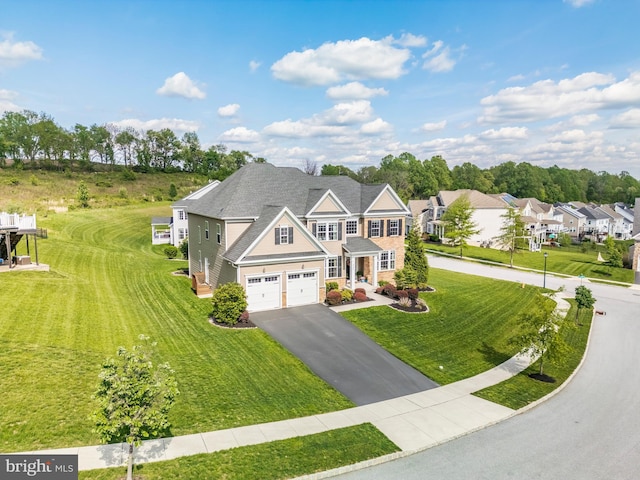 view of front of house featuring an attached garage, driveway, and a front yard