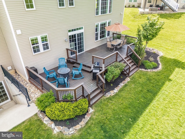 back of property with a wooden deck, outdoor dining space, and a lawn